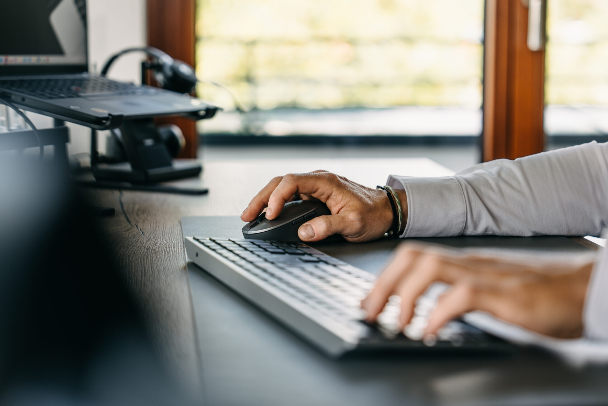 Arbeitsplatz bei ZEIS mit Laptop, Tastatur und Headset