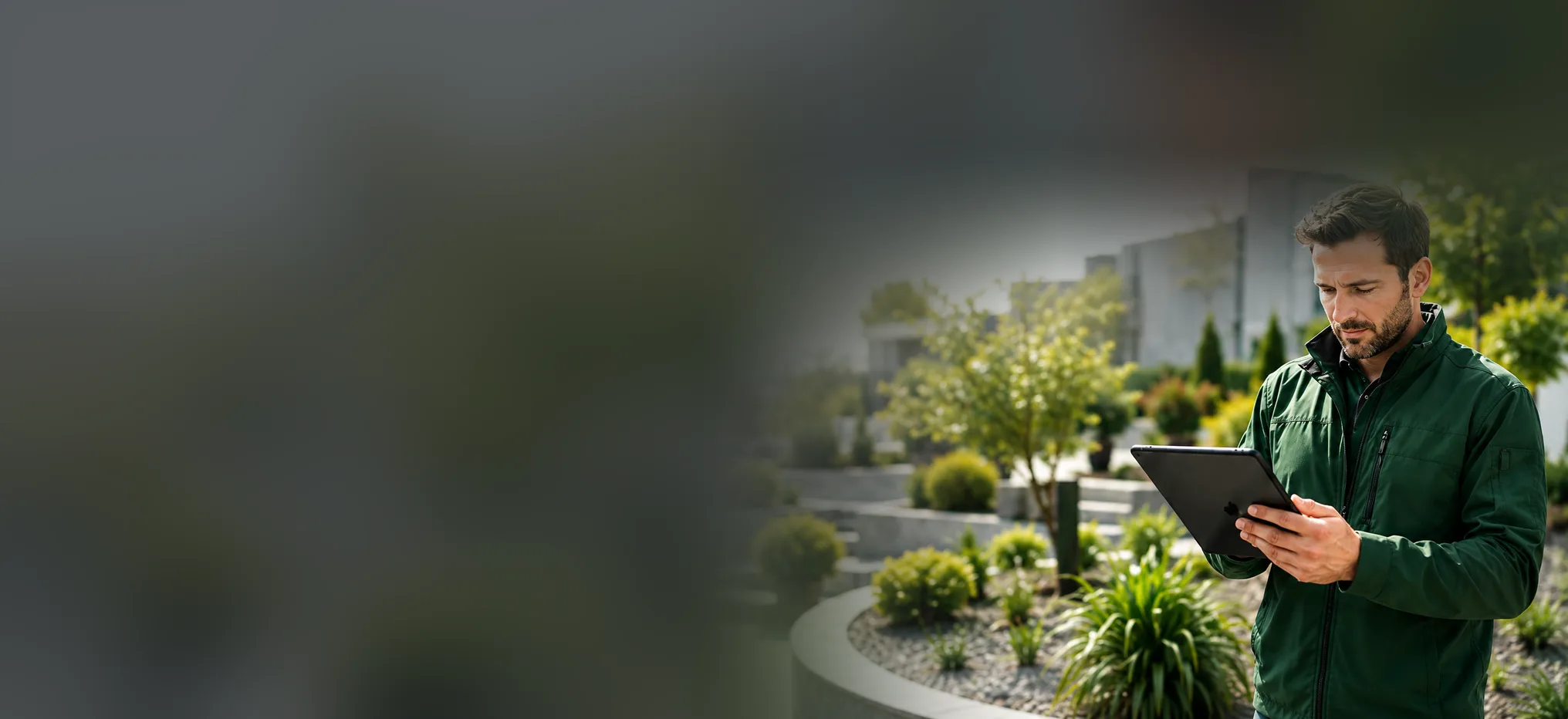 Garten- und Landschaftsbauer pr&uuml;ft auf dem Tablet ein Projekt in einer Gartenanlage